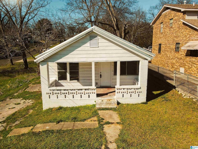 bungalow-style home with fence, a porch, and a front yard