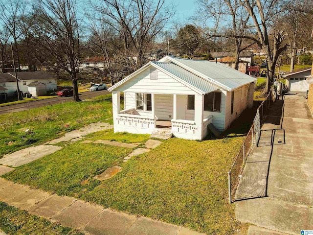 bungalow-style home featuring a porch, a front yard, and metal roof