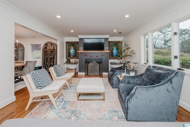 living room with baseboards, ornamental molding, wood finished floors, and recessed lighting