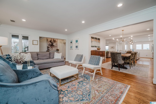 living area featuring light wood-style floors, visible vents, a chandelier, and recessed lighting