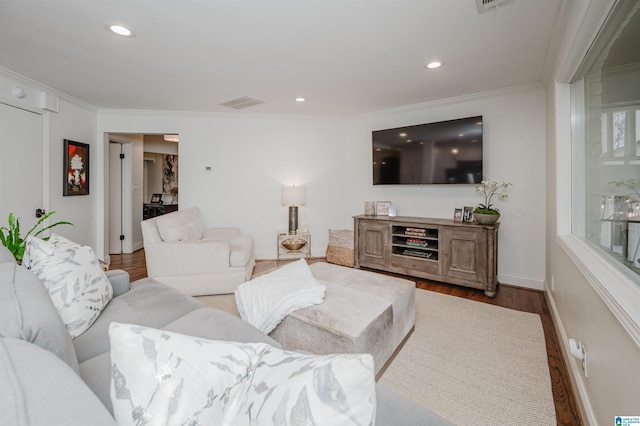 living room with ornamental molding, recessed lighting, visible vents, and wood finished floors