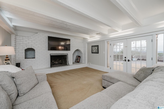 living room with a fireplace, baseboards, french doors, beam ceiling, and carpet