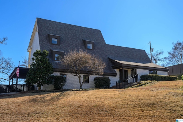 view of front of house featuring brick siding and a front yard