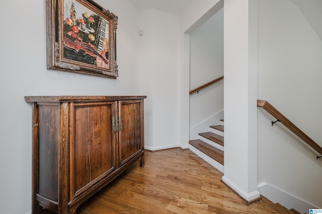 stairway with wood finished floors and baseboards