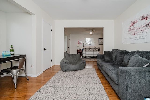 living area featuring ceiling fan, wood finished floors, and baseboards