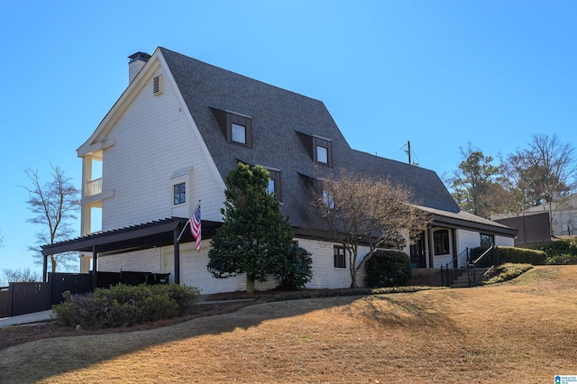 exterior space featuring a garage, roof with shingles, a chimney, and a front lawn