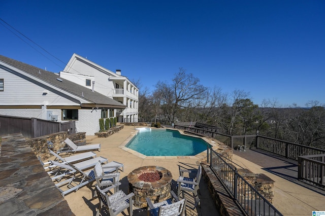 view of pool featuring a patio area, a fire pit, and a fenced in pool