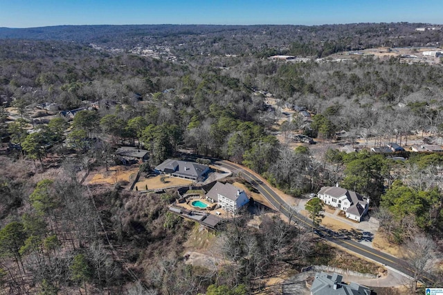 bird's eye view with a wooded view