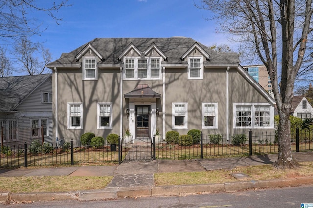 view of front facade with a fenced front yard and a shingled roof