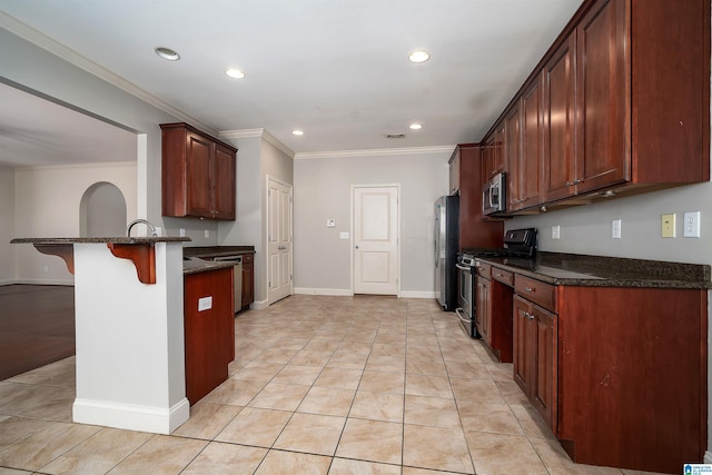 kitchen with light tile patterned floors, stainless steel appliances, a breakfast bar, a peninsula, and ornamental molding