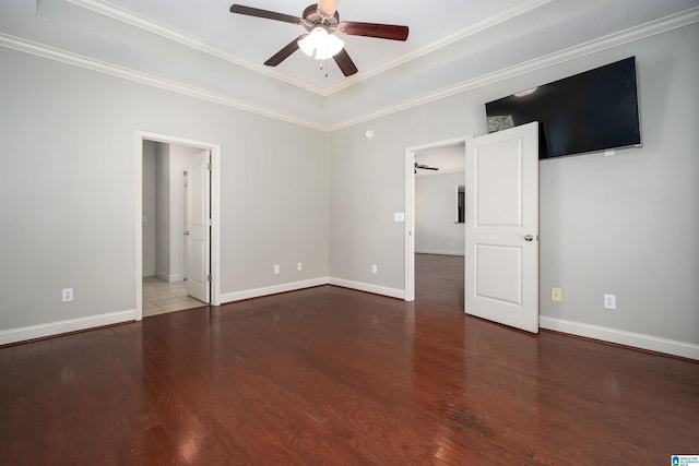 spare room with a ceiling fan, ornamental molding, baseboards, and wood finished floors