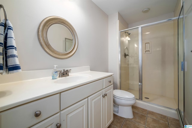 bathroom featuring a stall shower, vanity, toilet, and tile patterned floors