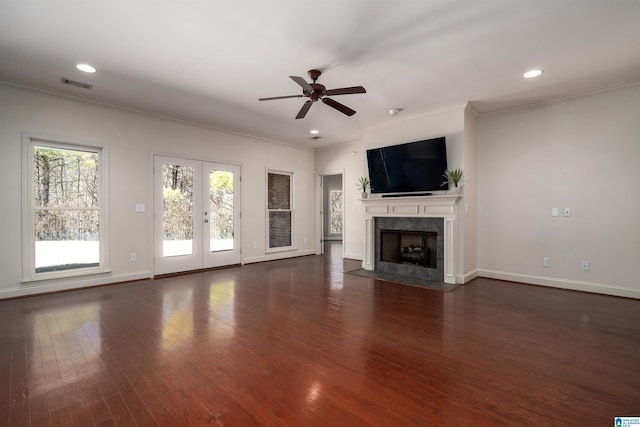 unfurnished living room featuring a fireplace, visible vents, dark wood-style flooring, and french doors