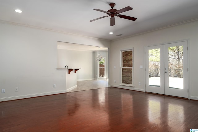 empty room featuring crown molding, wood finished floors, and french doors