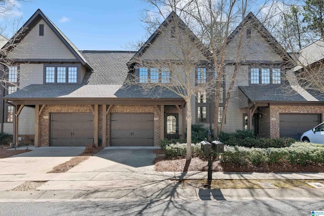 view of front facade featuring a garage, concrete driveway, brick siding, and roof with shingles