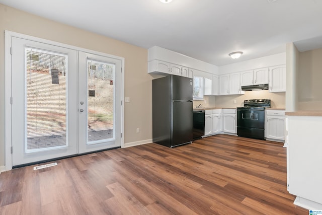 kitchen with visible vents, white cabinets, dark wood finished floors, under cabinet range hood, and black appliances