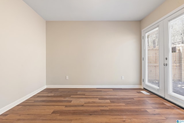 spare room with french doors, a wealth of natural light, and baseboards