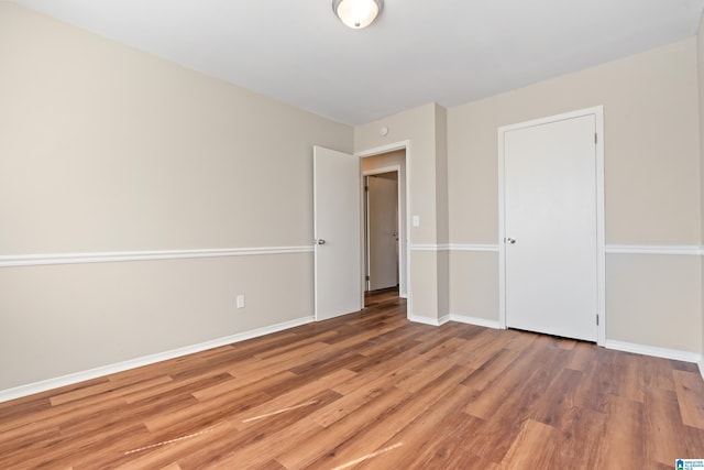 empty room with baseboards and light wood finished floors