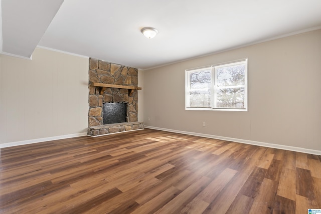 unfurnished living room with crown molding, a fireplace, baseboards, and wood finished floors