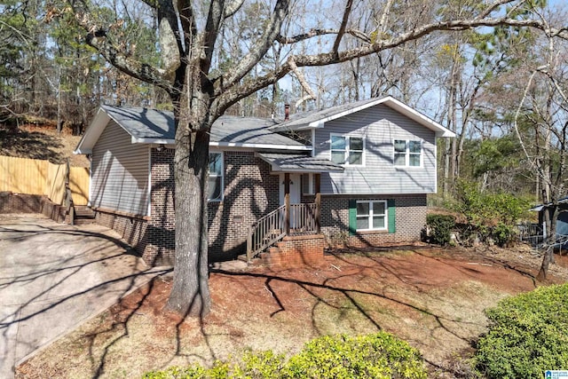 tri-level home with brick siding and fence