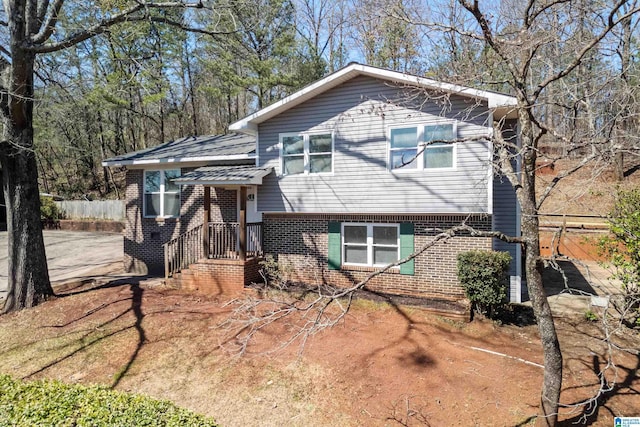 tri-level home with brick siding and fence