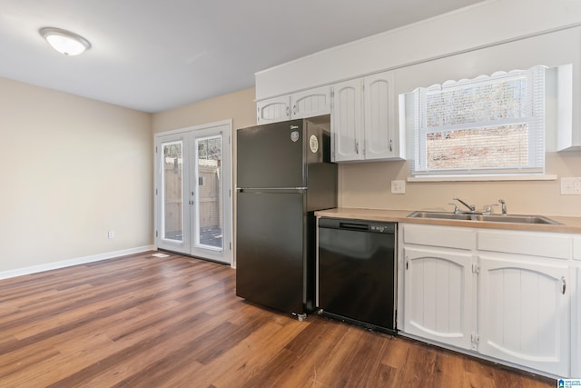 kitchen with baseboards, wood finished floors, black appliances, white cabinetry, and a sink