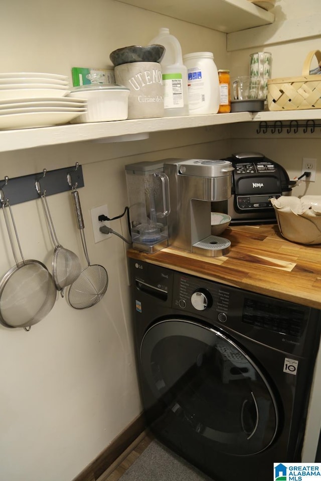 laundry area featuring baseboards, washer / clothes dryer, and laundry area