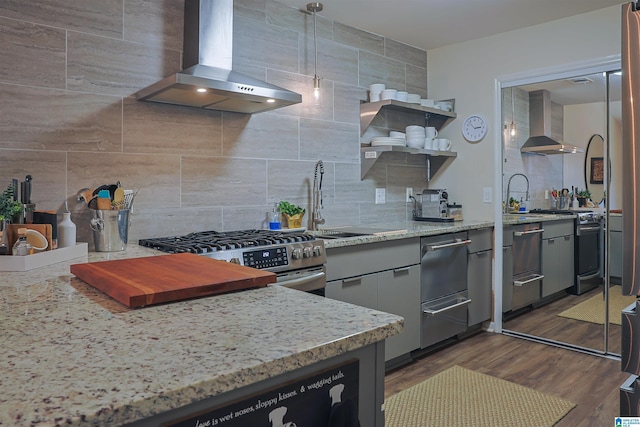 kitchen featuring dark wood-style floors, stainless steel range with gas stovetop, tasteful backsplash, and wall chimney exhaust hood