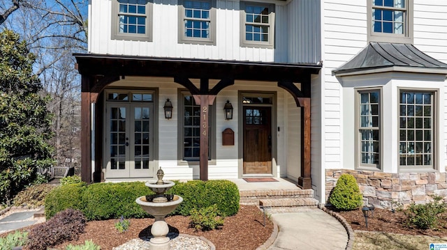 doorway to property with french doors, stone siding, metal roof, and a standing seam roof