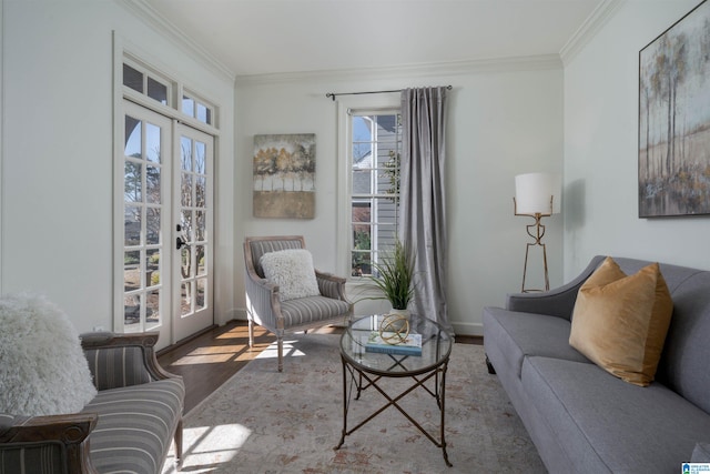 living area with wood finished floors, french doors, and ornamental molding