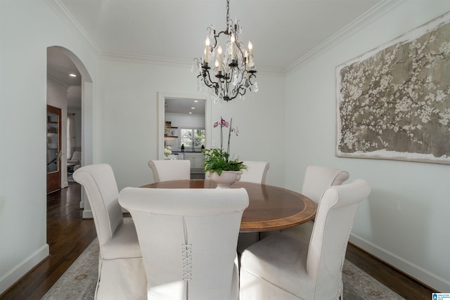 dining area featuring crown molding, wood finished floors, arched walkways, and baseboards