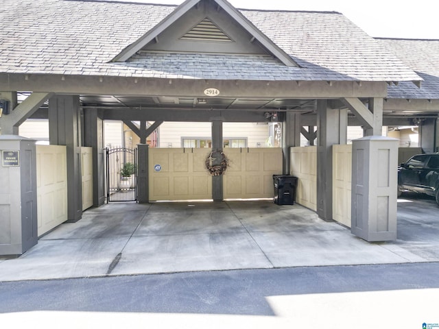 view of vehicle parking featuring fence and a gate