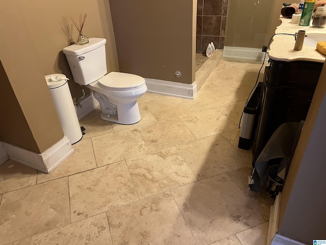 full bath with baseboards, a shower stall, toilet, and vanity