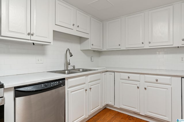 kitchen with dishwasher, light countertops, light wood-style flooring, white cabinetry, and a sink