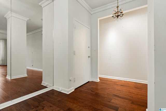 interior space featuring a notable chandelier, wood finished floors, baseboards, and ornamental molding