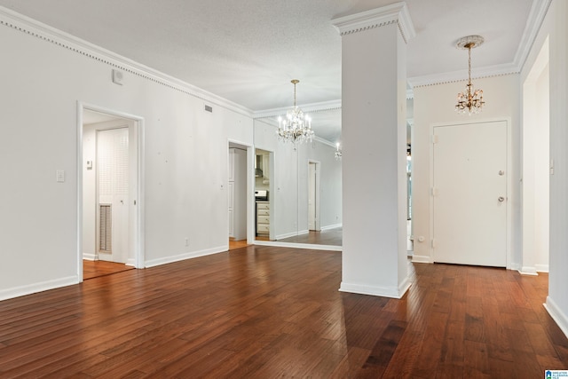 empty room featuring a notable chandelier, hardwood / wood-style floors, baseboards, and ornamental molding