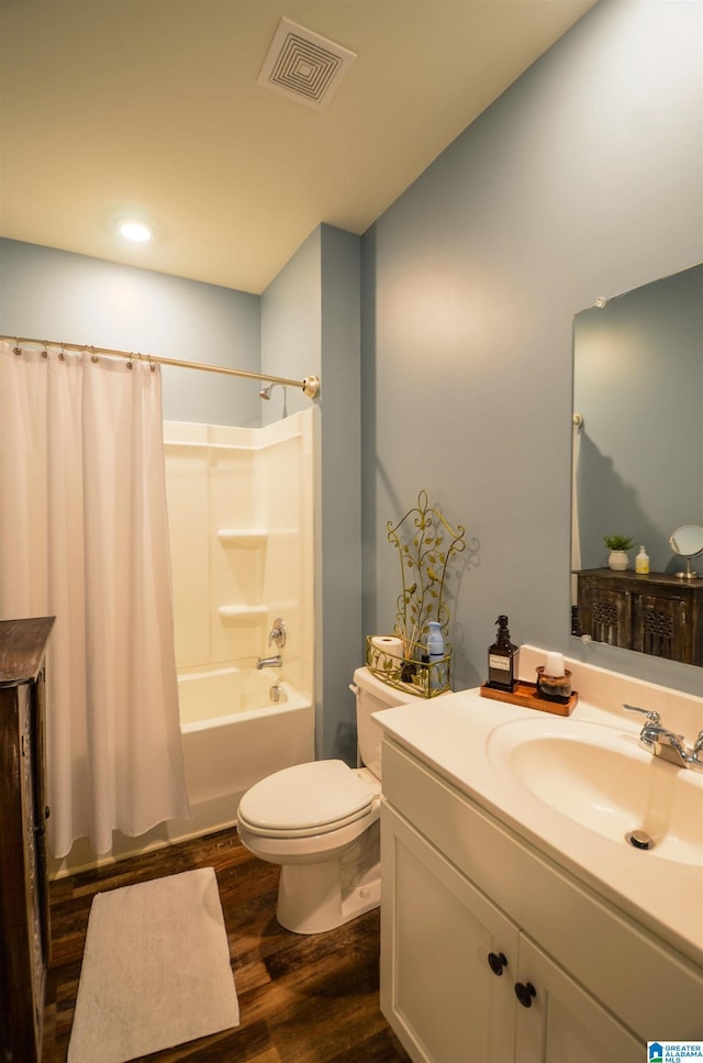 full bath with shower / bath combo, visible vents, toilet, wood finished floors, and vanity