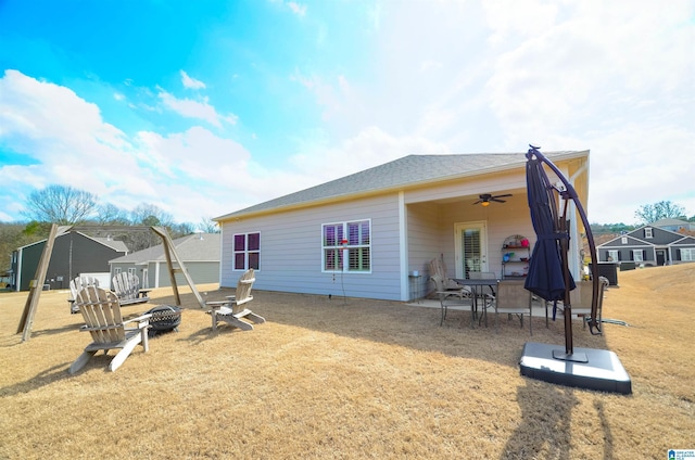 rear view of house featuring a yard, ceiling fan, a fire pit, and a patio