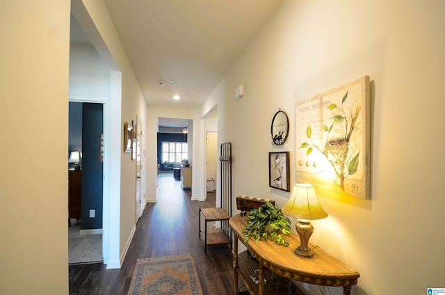 corridor featuring dark wood finished floors and baseboards