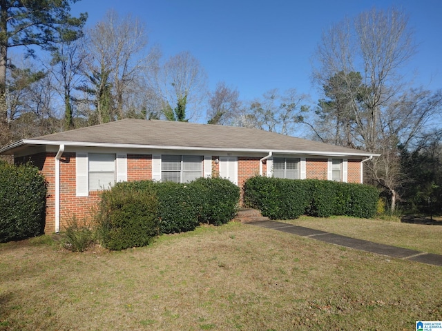 ranch-style home with a front yard and brick siding