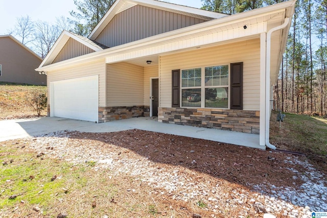 view of front facade with stone siding, board and batten siding, an attached garage, and driveway