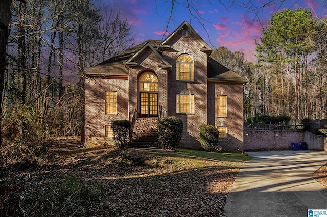 view of front of house with french doors, brick siding, and driveway