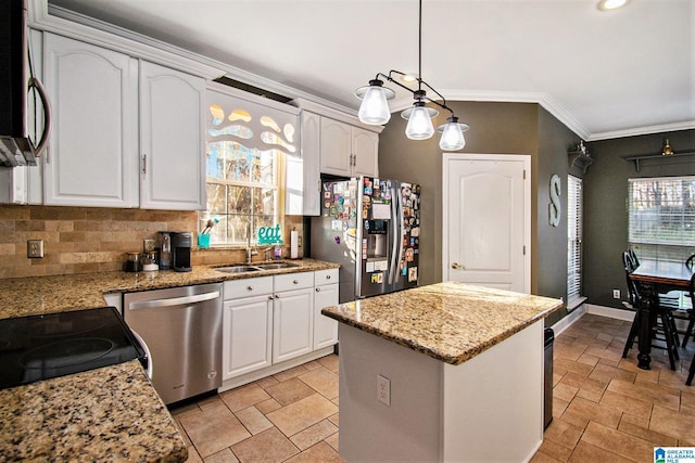 kitchen with a kitchen island, crown molding, appliances with stainless steel finishes, white cabinets, and a sink