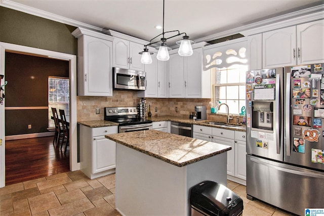 kitchen featuring tasteful backsplash, white cabinets, appliances with stainless steel finishes, and a sink