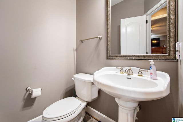 bathroom with toilet and baseboards