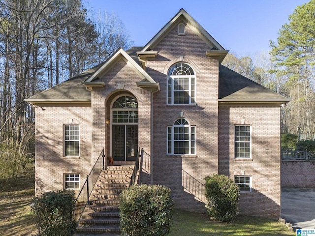 view of front of property featuring brick siding and a shingled roof