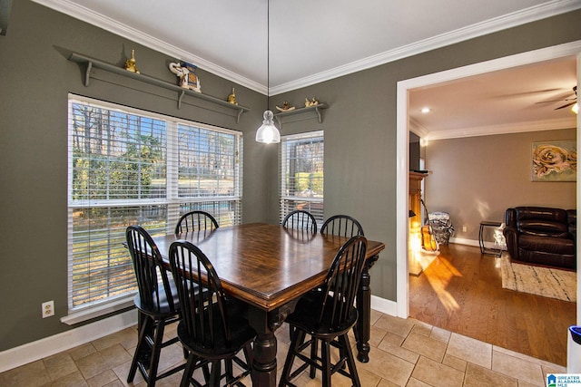 dining area featuring baseboards, a ceiling fan, stone tile flooring, and crown molding