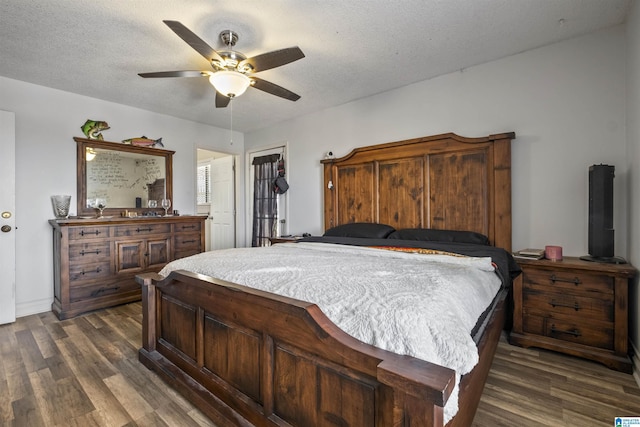 bedroom with a textured ceiling, a ceiling fan, and dark wood-style flooring