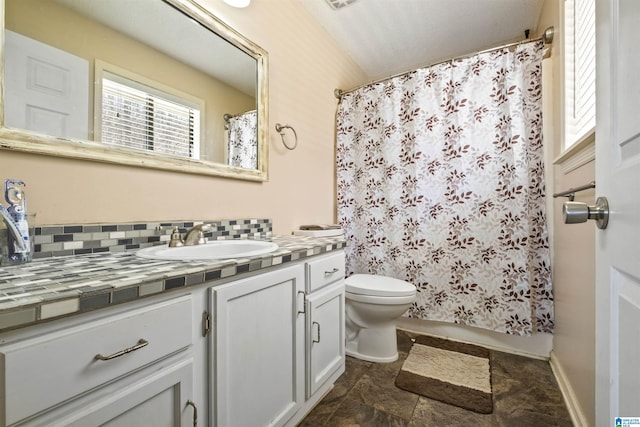 bathroom featuring tasteful backsplash, baseboards, vanity, and toilet