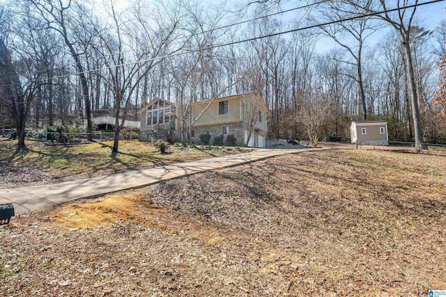 view of front facade with stone siding, fence, concrete driveway, and stucco siding